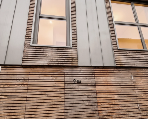 Vue de face d'une maison à façade en bardage bois agricole et habillage zinc, Le Pellerin (44)