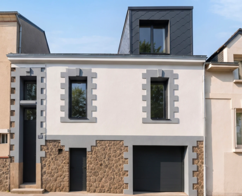 Façade d'une maison de ville à Nantes avec lucarne contemporaine en zinc noir créée en toiture, chaînages de pierre et garage en soubassement