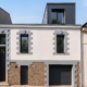 Façade d'une maison de ville à Nantes avec lucarne contemporaine en zinc noir créée en toiture, chaînages de pierre et garage en soubassement