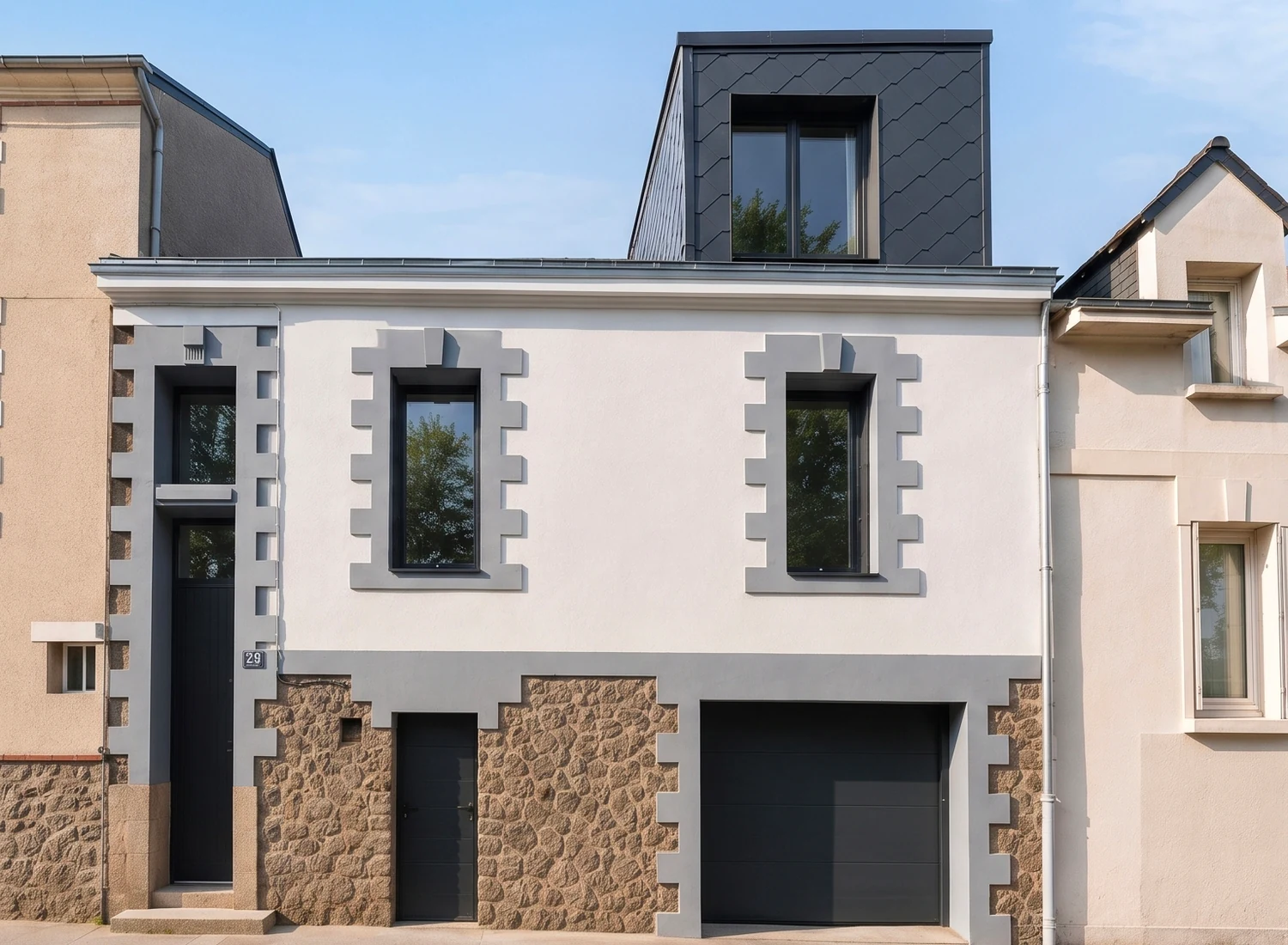 Façade d'une maison de ville à Nantes avec lucarne contemporaine en zinc noir créée en toiture, chaînages de pierre et garage en soubassement