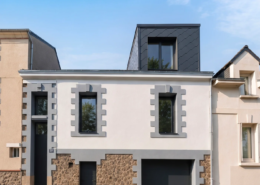 Façade principale d'une maison à Nantes, chaînages de pierre et enduit clair, avec lucarne en zinc noir mat créée en toiture