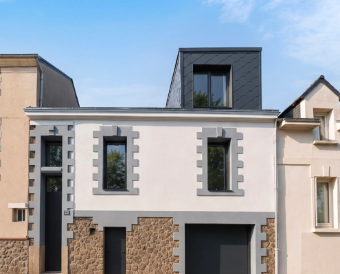 Façade principale d'une maison à Nantes, chaînages de pierre et enduit clair, avec lucarne en zinc noir mat créée en toiture